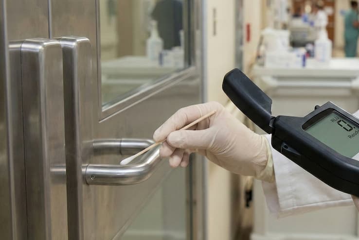 Operatore che utilizza bioluminometro ATP per verifica superfici